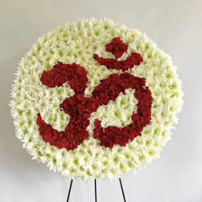 Round floral standing tribute with red symbol on a white flower background