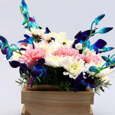 Colorful bouquet in a wooden box with pink and white flowers