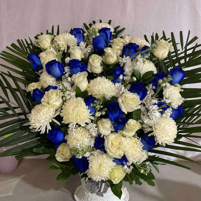 Blue and white rose bouquet with white mums in a vase