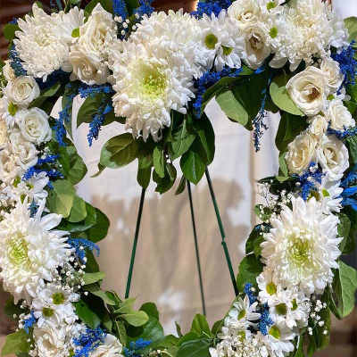 Heart-shaped floral wreath with white blooms and blue accents