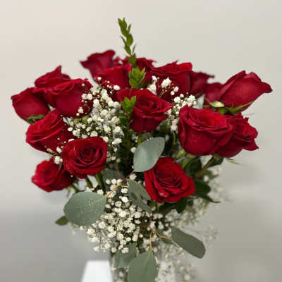Bouquet of red roses with baby's breath in a glass vase
