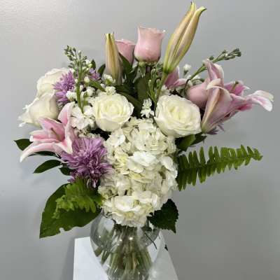 Pink lilies and white roses in a glass vase