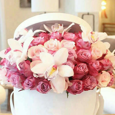 Pink and white roses with orchids in a white hatbox