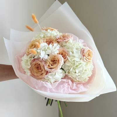 Peach roses and white hydrangeas wrapped in pink and white paper
