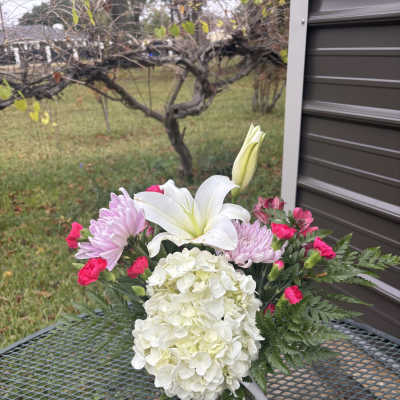 Bouquet with white lilies, pink chrysanthemums, and white hydrangea in a glass vase