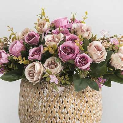 Pink and cream roses arranged in a woven basket vase