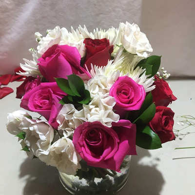 Pink and white roses with white daisies in a glass vase