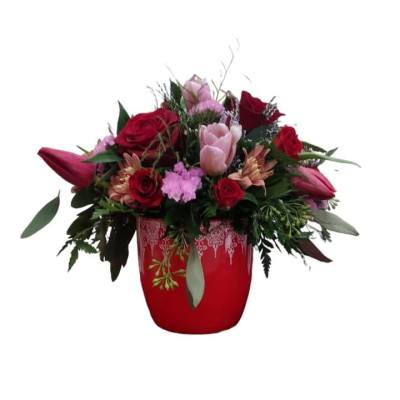 Red and pink flower arrangement in a red vase