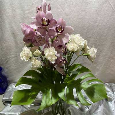 Pink orchids and white roses in a clear glass vase