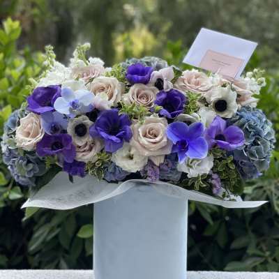 Lavender, white, and pink bouquet in a pale blue box
