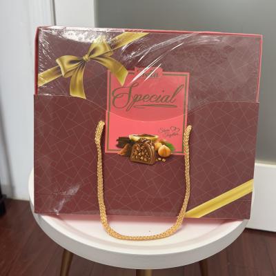 Maroon gift bag with gold ribbon and chocolate box design