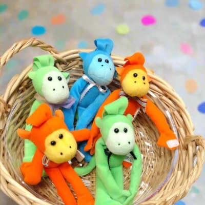Basket of colorful plush monkey toys on a polka dot background