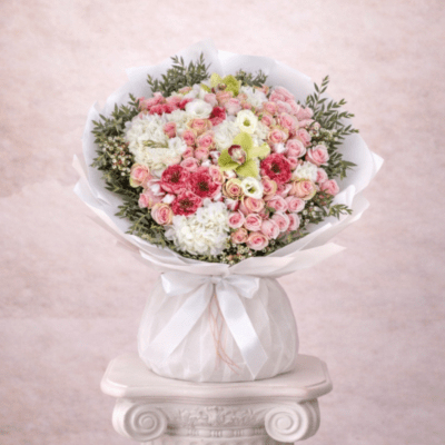 Large round bouquet of pink spray roses and white hydrangeas wrapped in white paper and ribbon