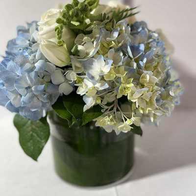 Blue and white hydrangea bouquet in a green vase