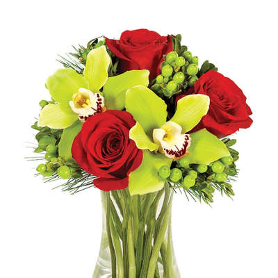 Red roses and green orchids in a clear glass vase