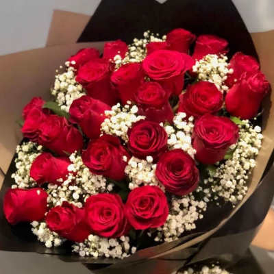 Bouquet of red roses with white baby's breath in black wrapping