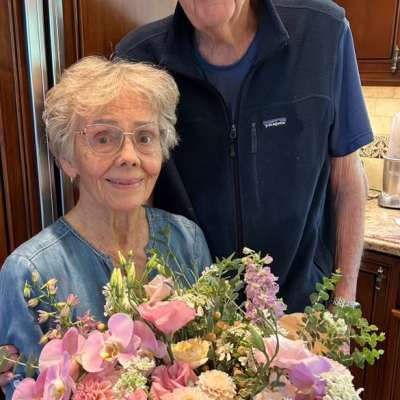 Woman holding a large pastel bouquet with pink and lavender flowers