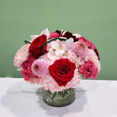 Bouquet of red and pink flowers in a clear glass vase