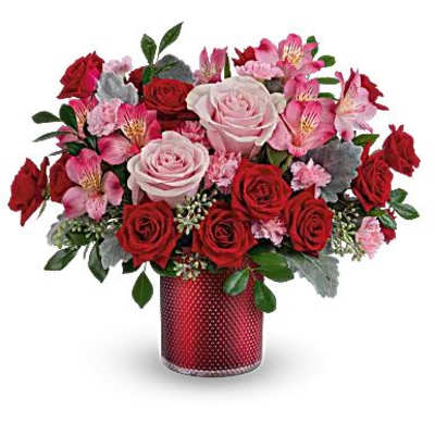 Red and pink rose bouquet in a red textured vase