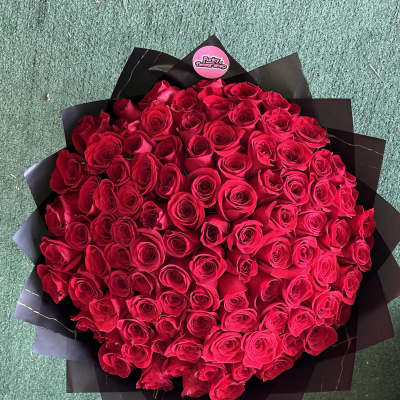 Large bouquet of red roses wrapped in black paper