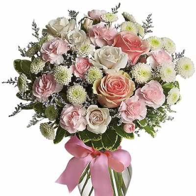 Pink and white rose bouquet in a glass vase with a pink ribbon