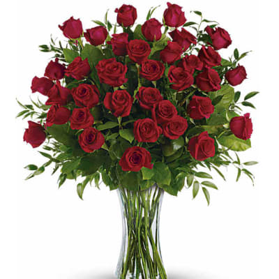 Red roses arranged in a clear glass vase
