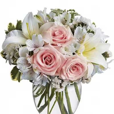 Pink roses and white lilies arranged in a clear glass vase