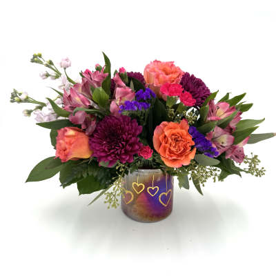Mixed bouquet in a purple glass vase with heart designs