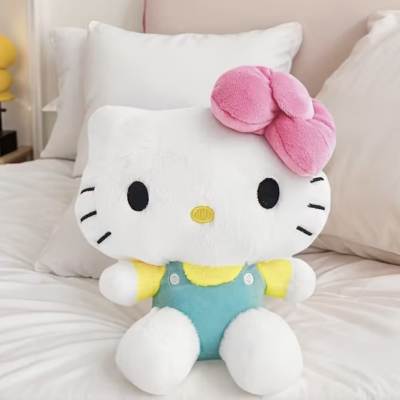 Hello Kitty plush toy sitting on a bed with a pink bow
