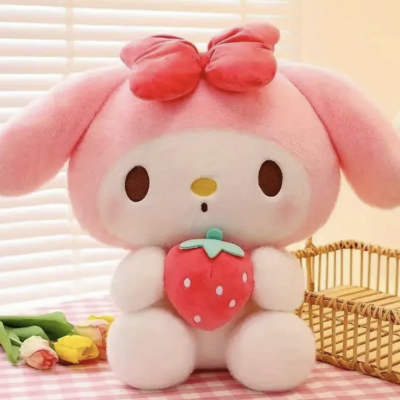Pink plush bunny holding a strawberry with a small bouquet nearby