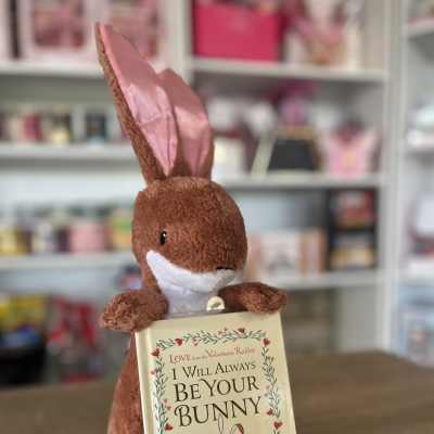 Plush brown bunny holding a book that says "I Will Always Be Your Bunny"