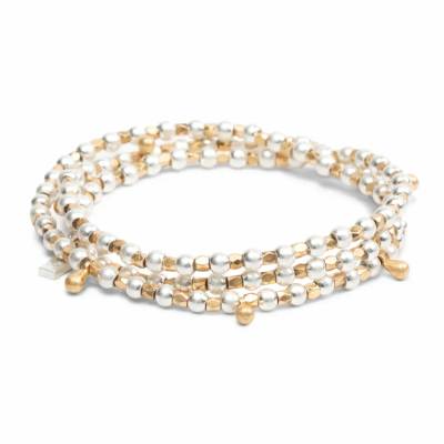 Gold and silver beaded wrap bracelet coiled in a circle on a white background