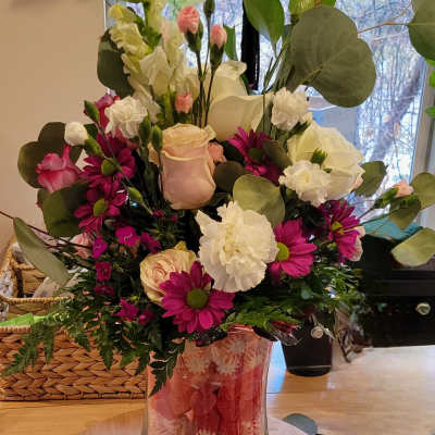 Mixed bouquet of pink, white, and magenta flowers in a clear glass vase