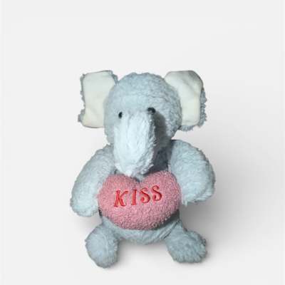 Plush elephant holding a pink heart with the word KISS