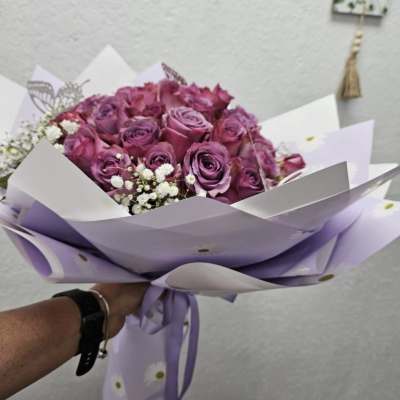 Bouquet of purple roses wrapped in lavender paper