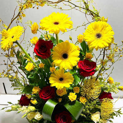 Bouquet of yellow gerbera daisies and red roses with greenery