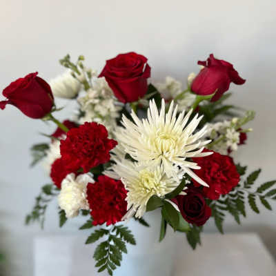 Red roses and white chrysanthemums in a white vase