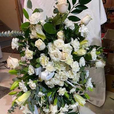 Large white floral standing spray with roses and lilies