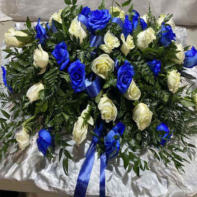 Blue and white rose arrangement with ribbon on satin fabric