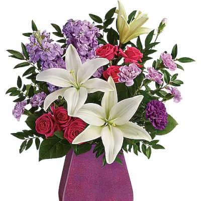 Bouquet of white lilies, pink roses, and purple flowers in a glittery vase