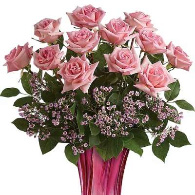 Pink roses arranged in a tall pink glass vase
