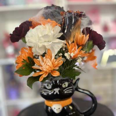 Orange and white flowers arranged in a black cat-shaped vase