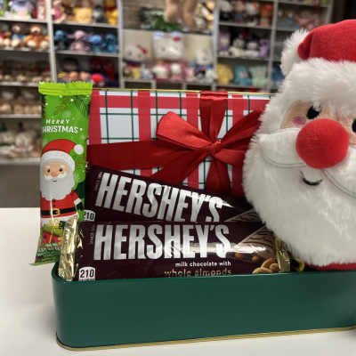 Christmas gift basket with candy bars and a Santa plush