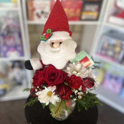 Santa figurine with red and white flowers in a vase