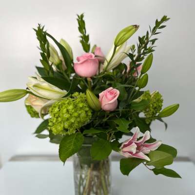 Pink roses and lilies in a clear glass vase