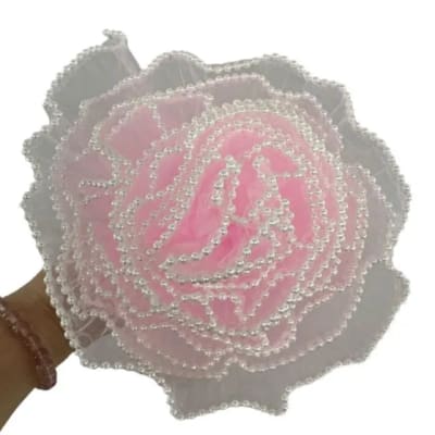 Pink beaded artificial rose held in a hand