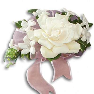 White rose corsage with small white flowers and pink ribbon