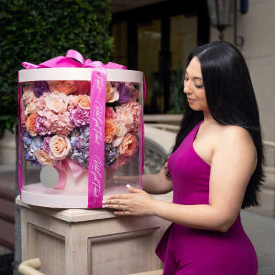 Large pink and peach rose bouquet in a clear round box with a ribbon