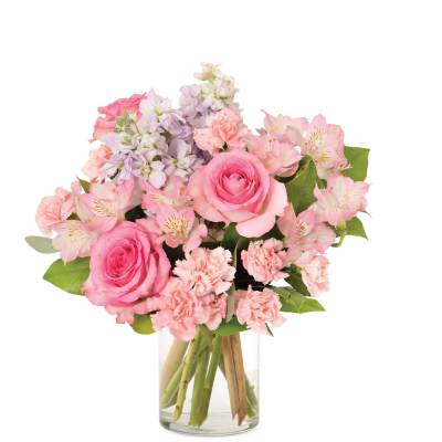 Pink rose, carnation, and alstroemeria bouquet with lavender stock in a clear glass vase