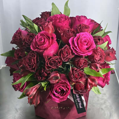 Bouquet of hot pink and burgundy roses in a pink box